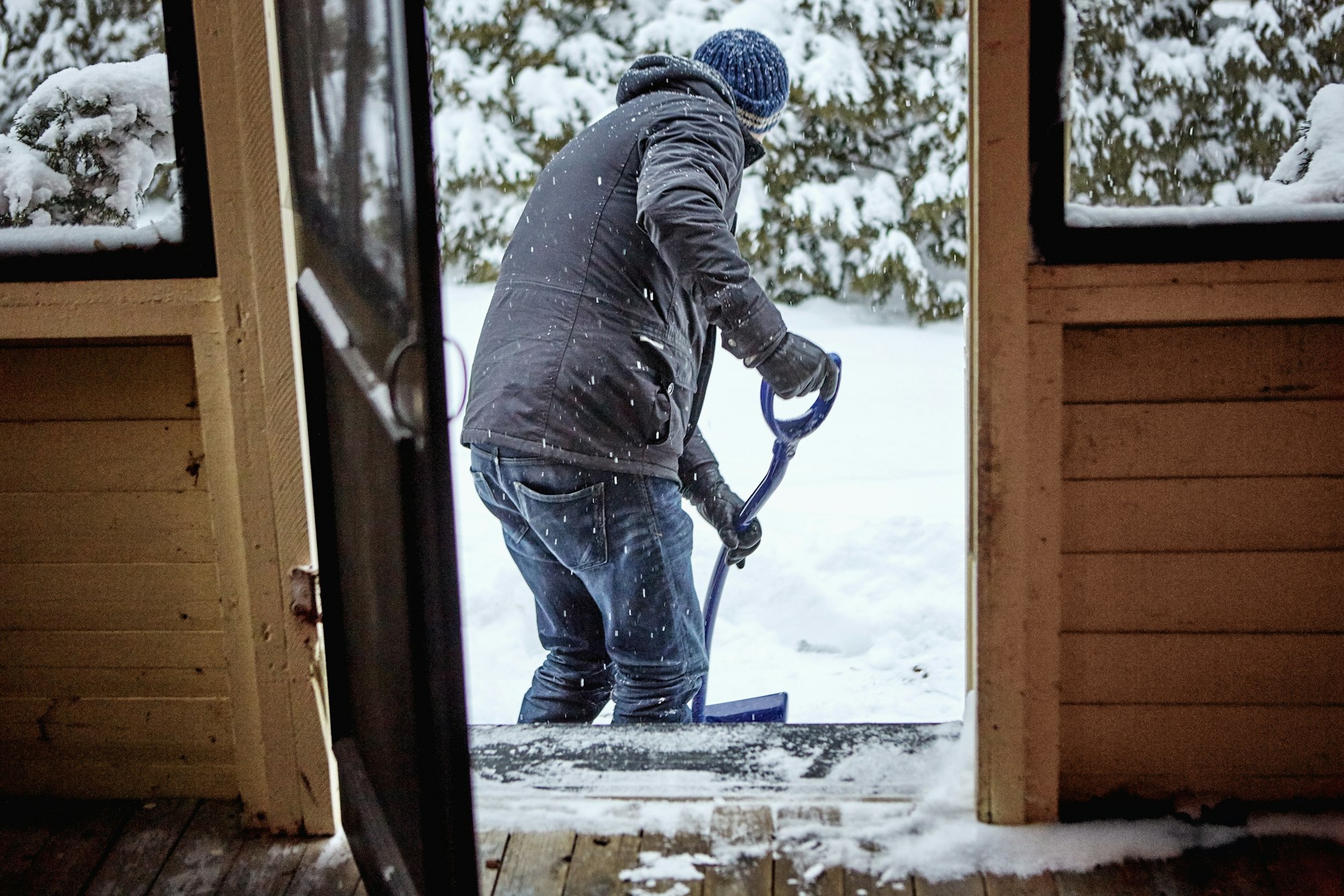 Man shovelling snow from pathway, rear view